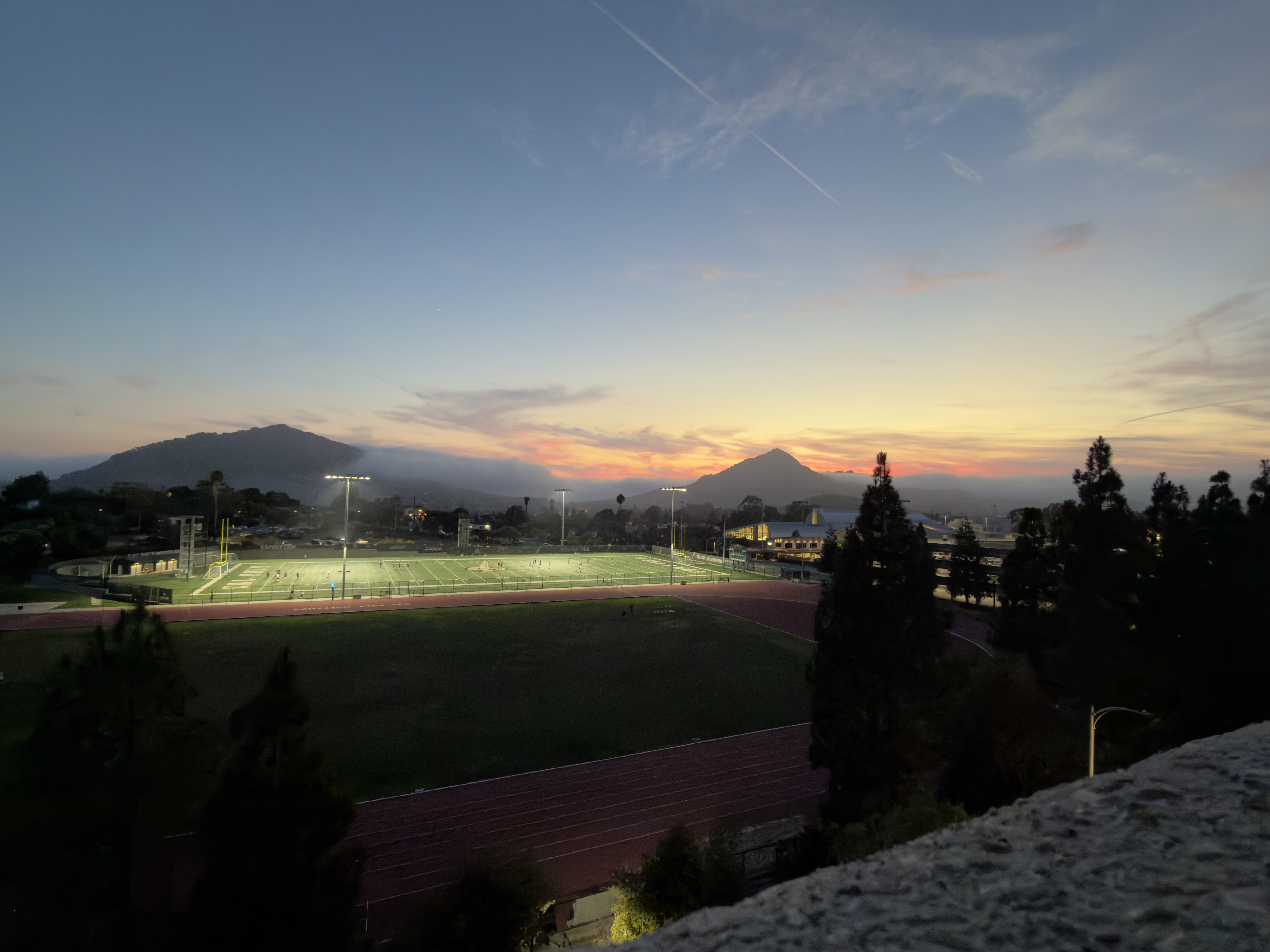 A landscape photo of Madonna Mountain with an aerial view of the Cal Poly Sports fields.